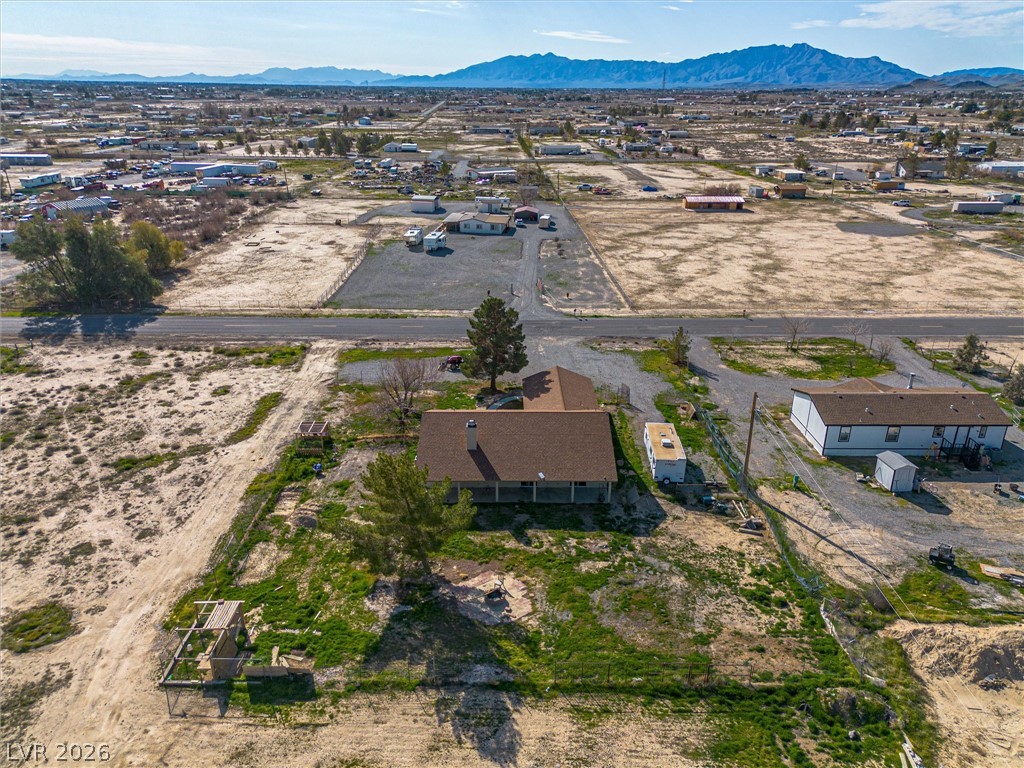 2780 West Simkins Road Pahrump, NV 89060 - Photo 40 of 40 An aerial perspective reveals a vast desert landscape dotted with structures and distant mountains.