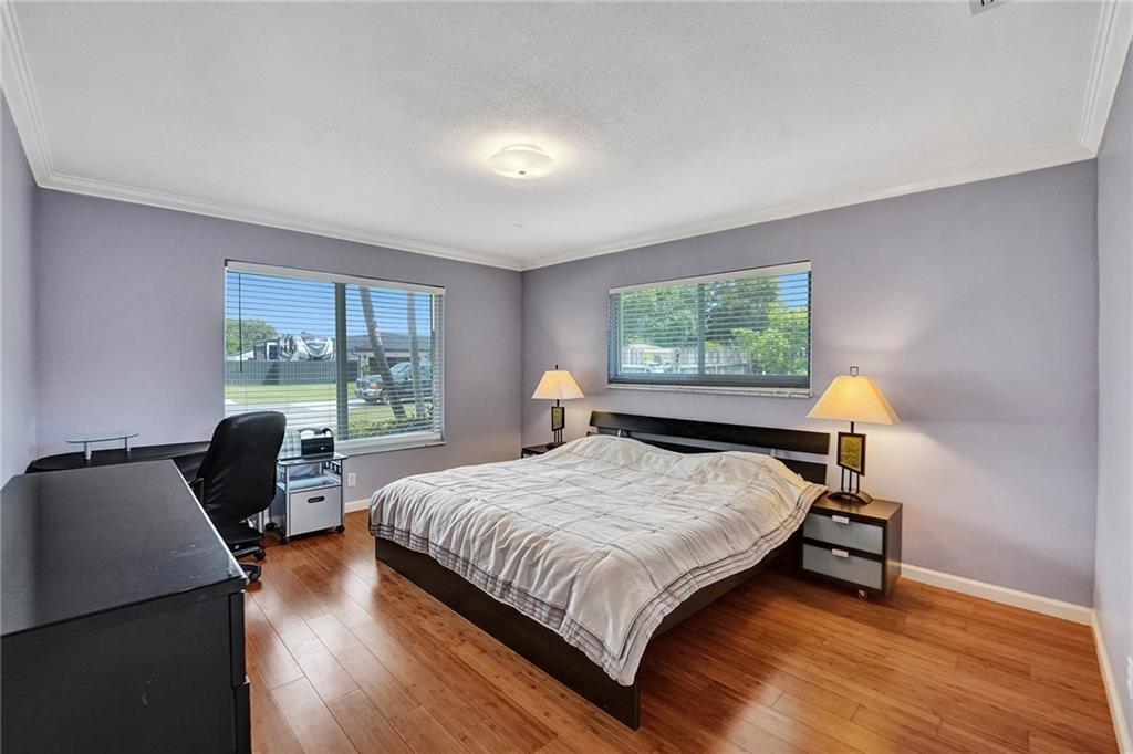 5760 Southwest 7th Street Plantation, FL 33317 - Photo 22 of 56 a bedroom with a bed a window and walk in closet with wooden floor