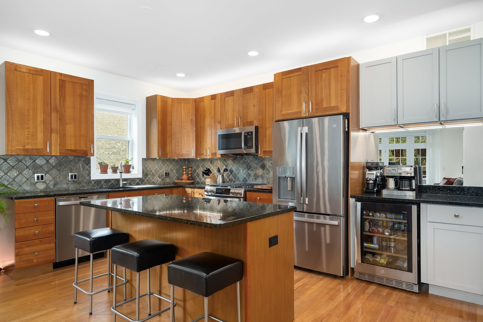 4826 North Winthrop Avenue, Unit 2S Chicago, IL 60640 - Photo 6 of 21 a kitchen with kitchen island granite countertop wooden cabinets and refrigerator