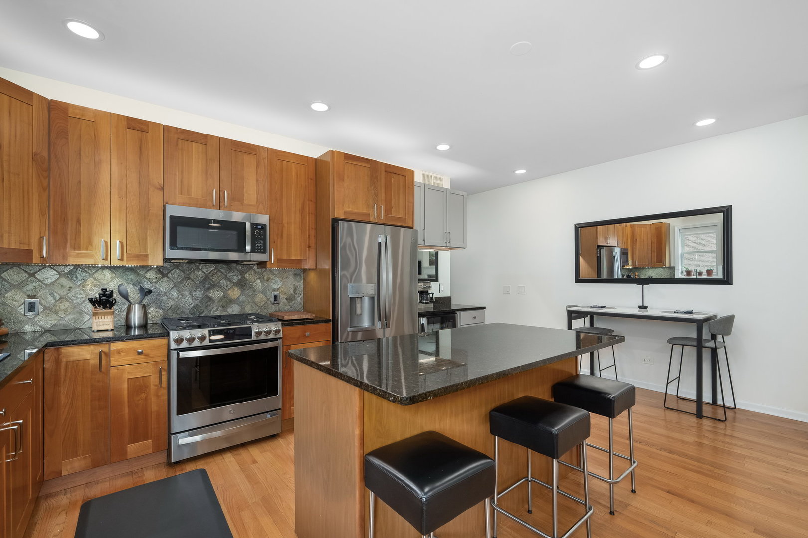 4826 North Winthrop Avenue, Unit 2S Chicago, IL 60640 - Photo 8 of 21 a kitchen with stainless steel appliances granite countertop a stove top oven a sink dishwasher a dining table and chairs with wooden floor