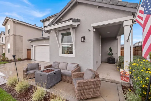 a patio with couches and a potted plant