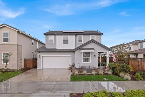 a front view of a house with a garden and plants