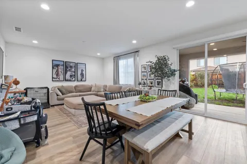 a living room with furniture a wooden floor and next to a window