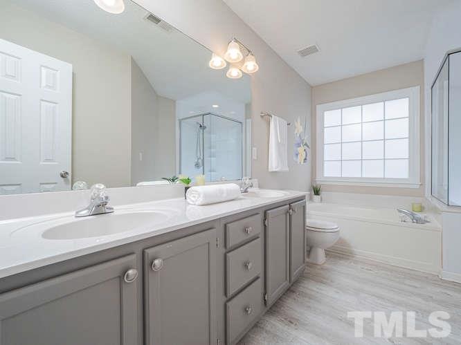 5520 Edgebury Road Raleigh, NC 27613 - Photo 15 of 29 a bathroom with a double vanity sink toilet mirror and bathtub
