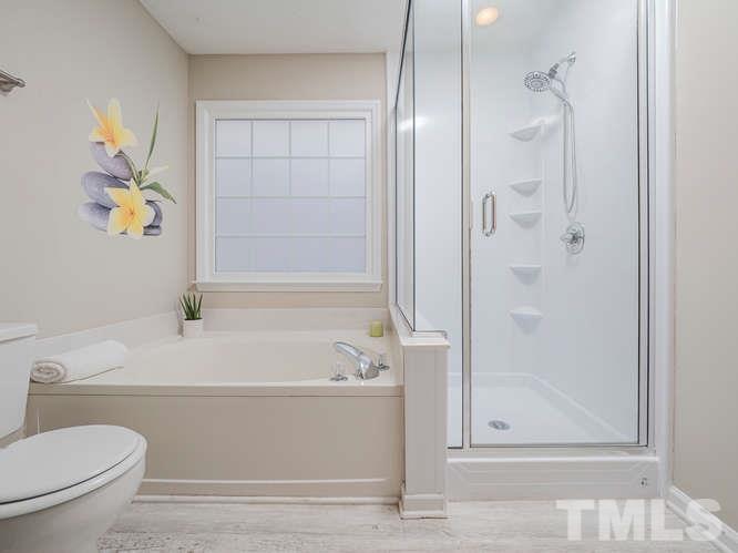 5520 Edgebury Road Raleigh, NC 27613 - Photo 17 of 29 a bathroom with a bathtub and a shower