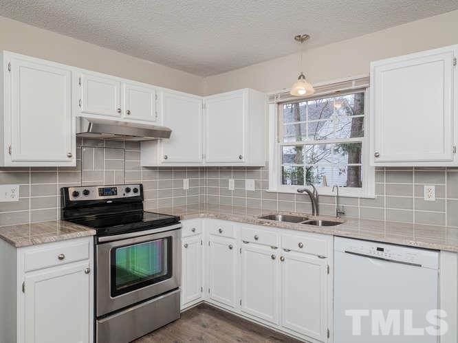 5520 Edgebury Road Raleigh, NC 27613 - Photo 4 of 29 a kitchen with granite countertop white cabinets and stainless steel appliances