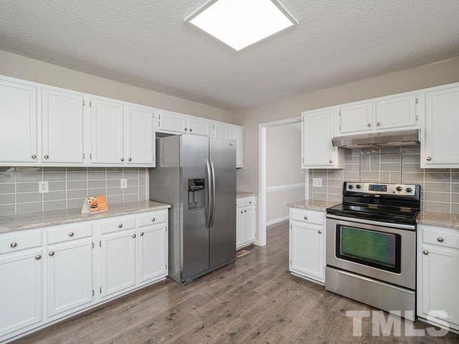 5520 Edgebury Road Raleigh, NC 27613 - Photo 5 of 29 a kitchen with stainless steel appliances white cabinets and a stove top oven