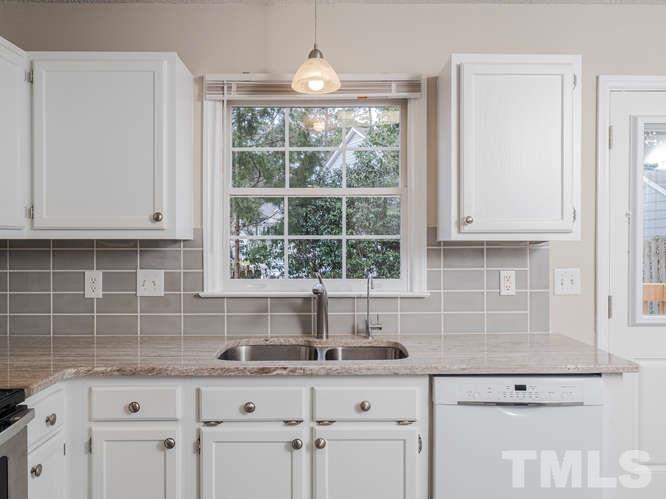 5520 Edgebury Road Raleigh, NC 27613 - Photo 6 of 29 a kitchen with stainless steel appliances granite countertop a sink a window and cabinets