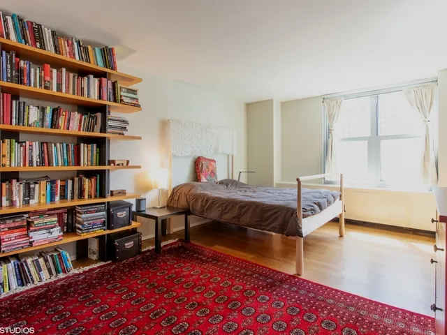 a living room with furniture and a book shelf