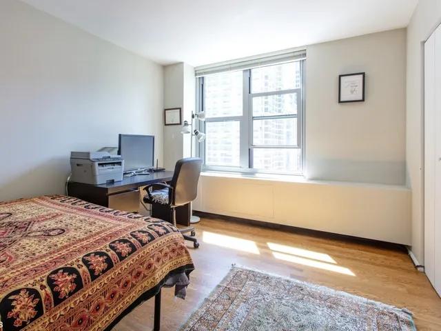 a bedroom with a bed a table and a window