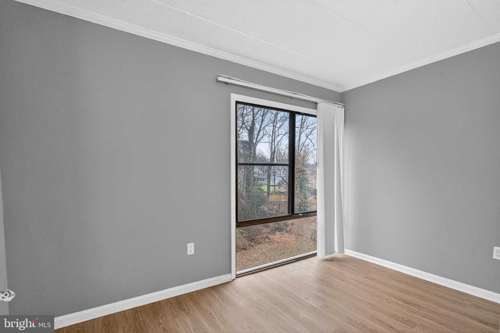 3301 Hewitt Avenue, Unit 403 Silver Spring, MD 20906 - Photo 12 of 19 an empty room with wooden floor and windows