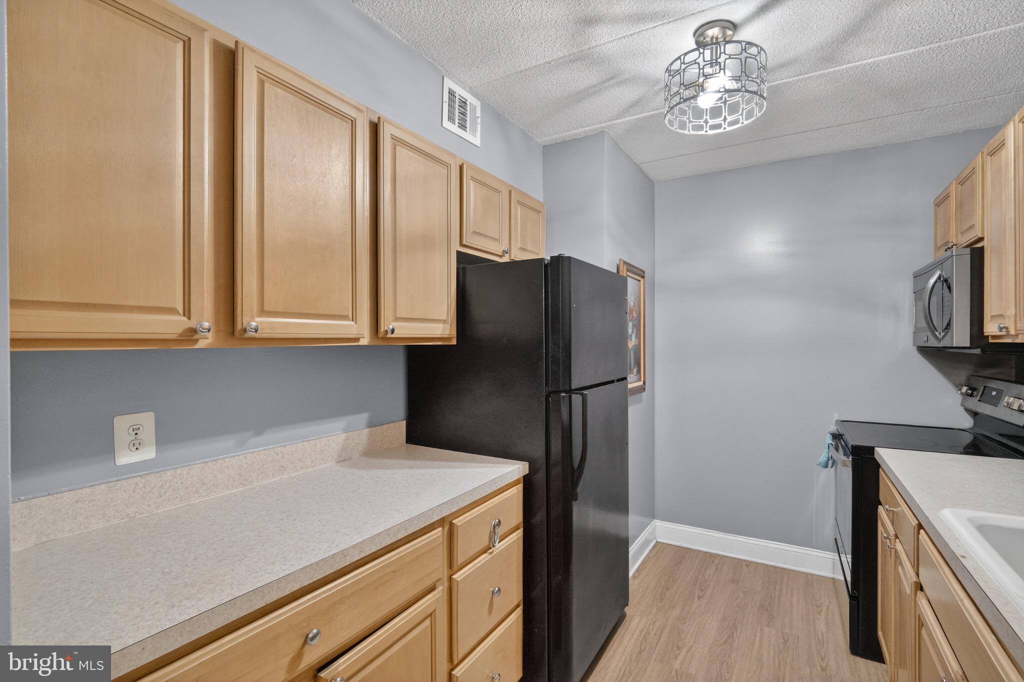 3301 Hewitt Avenue, Unit 403 Silver Spring, MD 20906 - Photo 4 of 19 a kitchen with stainless steel appliances a refrigerator and a stove top oven