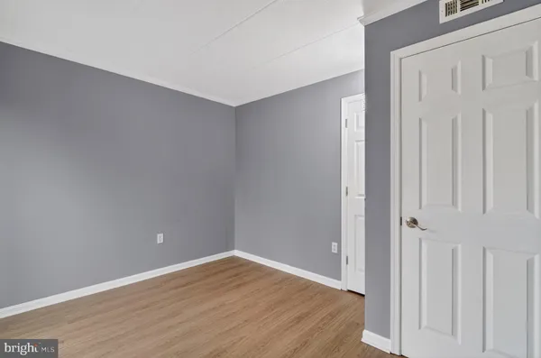 a view of an empty room with wooden floor