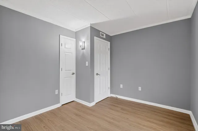 a view of an empty room with wooden floor