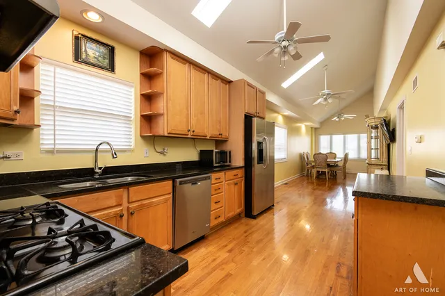 a kitchen with stainless steel appliances granite countertop a sink a stove and a refrigerator