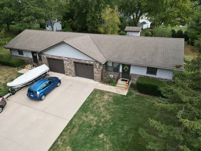 a aerial view of a house with table and chairs under an umbrella