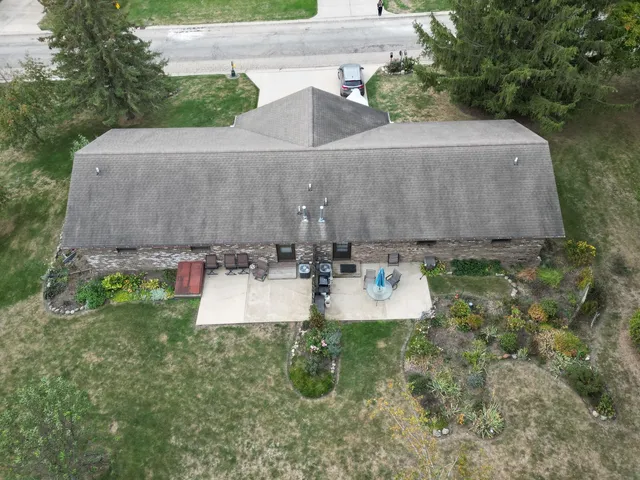 an aerial view of a house with yard and trees