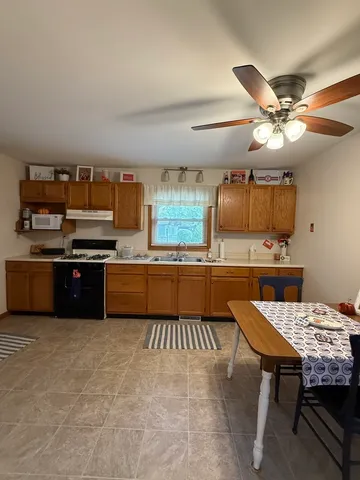 a kitchen with a stove a counter space a sink and a refrigerator