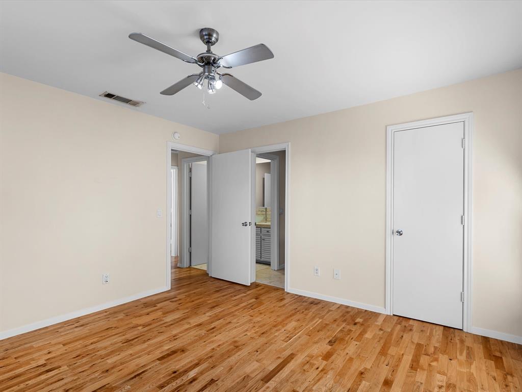 4110 Travis Street, Unit E Dallas, TX 75204 - Photo 17 of 23 a view of a room with wooden floor and a ceiling fan