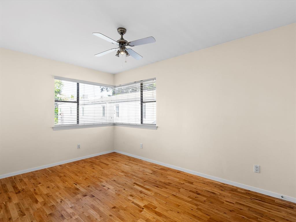 4110 Travis Street, Unit E Dallas, TX 75204 - Photo 18 of 23 a view of empty room with wooden floor and fan