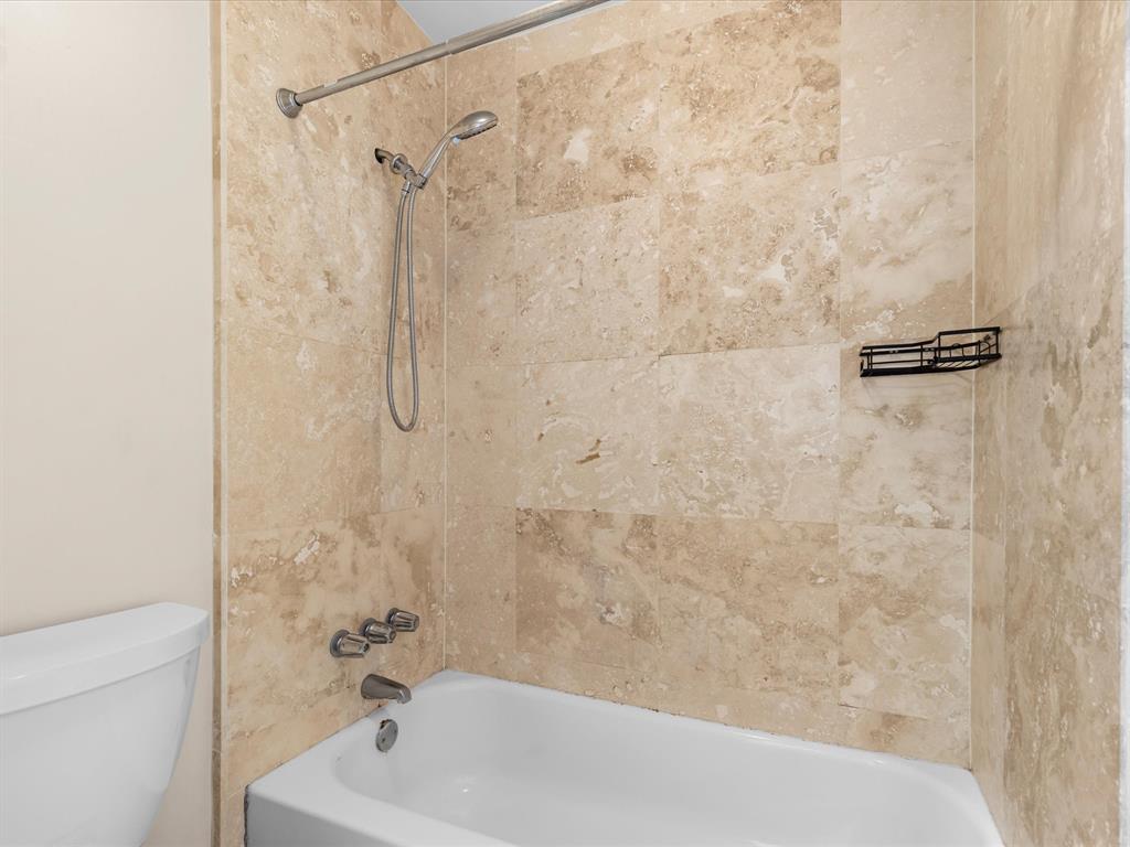 4110 Travis Street, Unit E Dallas, TX 75204 - Photo 21 of 23 a bathroom with a bath tub with a shower