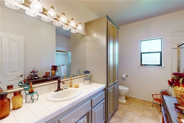 a kitchen with stainless steel appliances a stove a sink dishwasher a refrigerator with a dining table and chairs with wooden floor