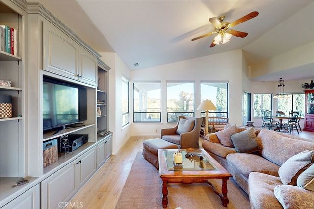 a living room with furniture and kitchen view with wooden floor