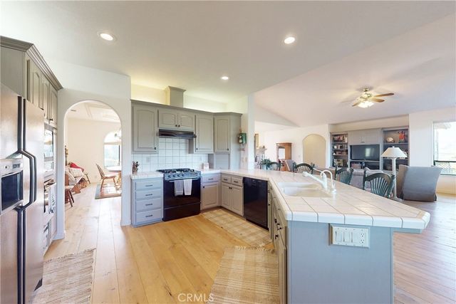 a kitchen with stainless steel appliances granite countertop a refrigerator and a stove top oven