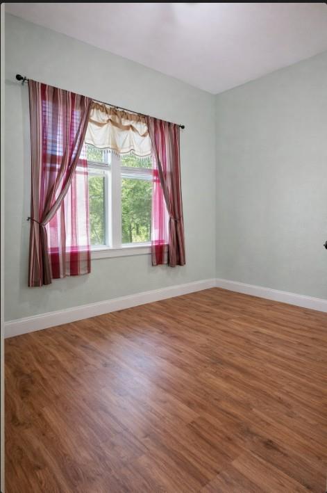 809 Southwest 5th Avenue Mineral Wells, TX 76067 - Photo 9 of 18 a view of a room with wooden floor and a window