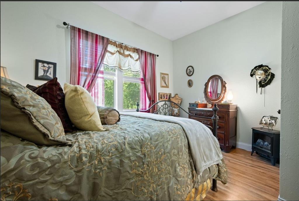 809 Southwest 5th Avenue Mineral Wells, TX 76067 - Photo 10 of 18 a bedroom with a bed and wooden floor