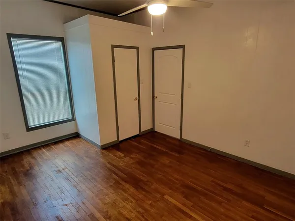 a view of an empty room with wooden floor