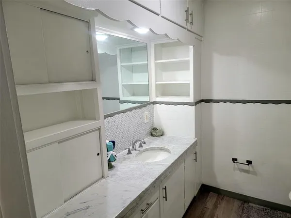 a bathroom with a granite countertop sink and a mirror
