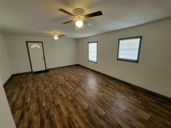 a view of a livingroom with wooden floor and a ceiling fan