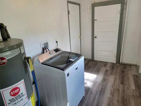 a utility room with wooden floor washer and dryer