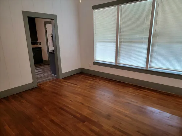 a view of a small space with wooden floor and a window