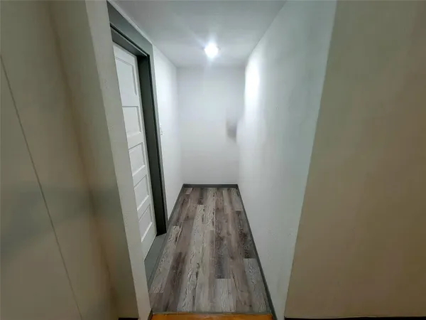 a view of a hallway with wooden floor