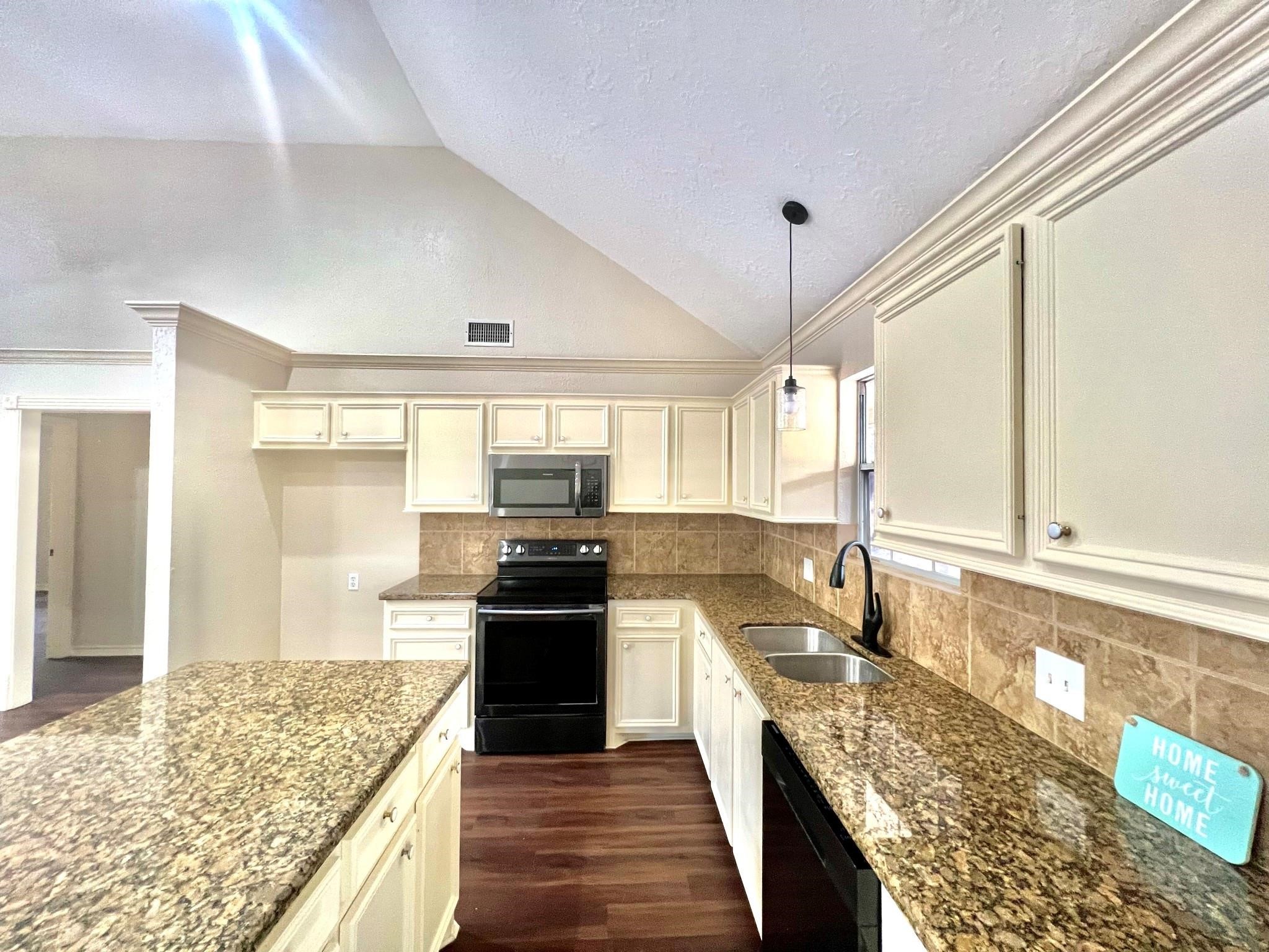 a kitchen with stainless steel appliances granite countertop a sink stove and refrigerator