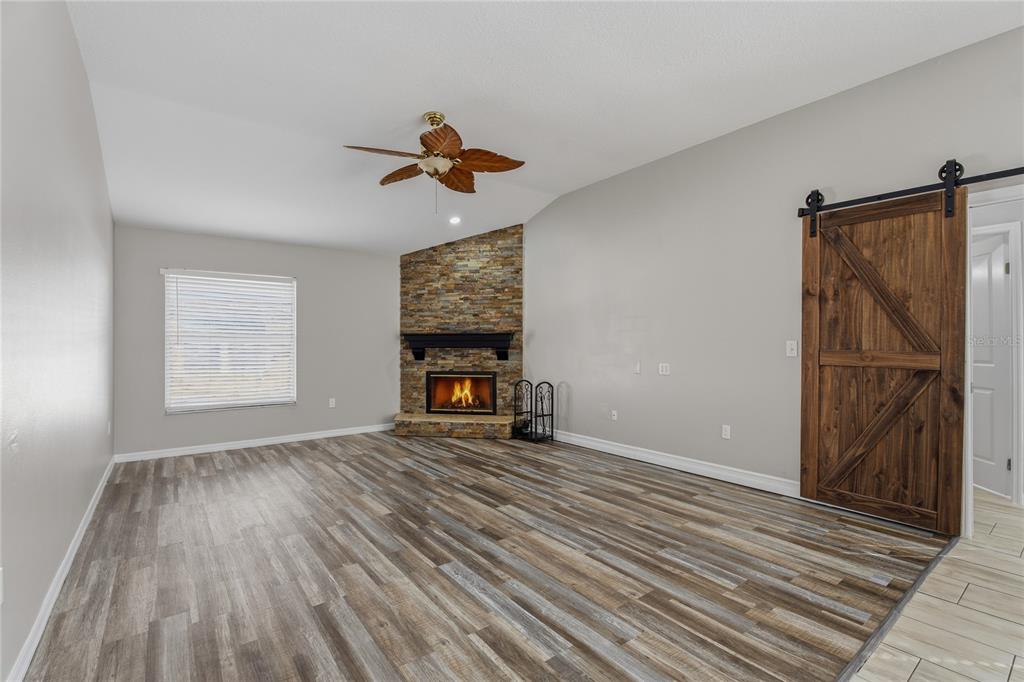 17431 Isbell Lane Odessa, FL 33556 - Photo 16 of 47 an empty room with wooden floor fireplace and windows