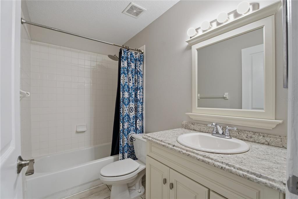 17431 Isbell Lane Odessa, FL 33556 - Photo 31 of 47 a bathroom with a granite countertop sink toilet and shower