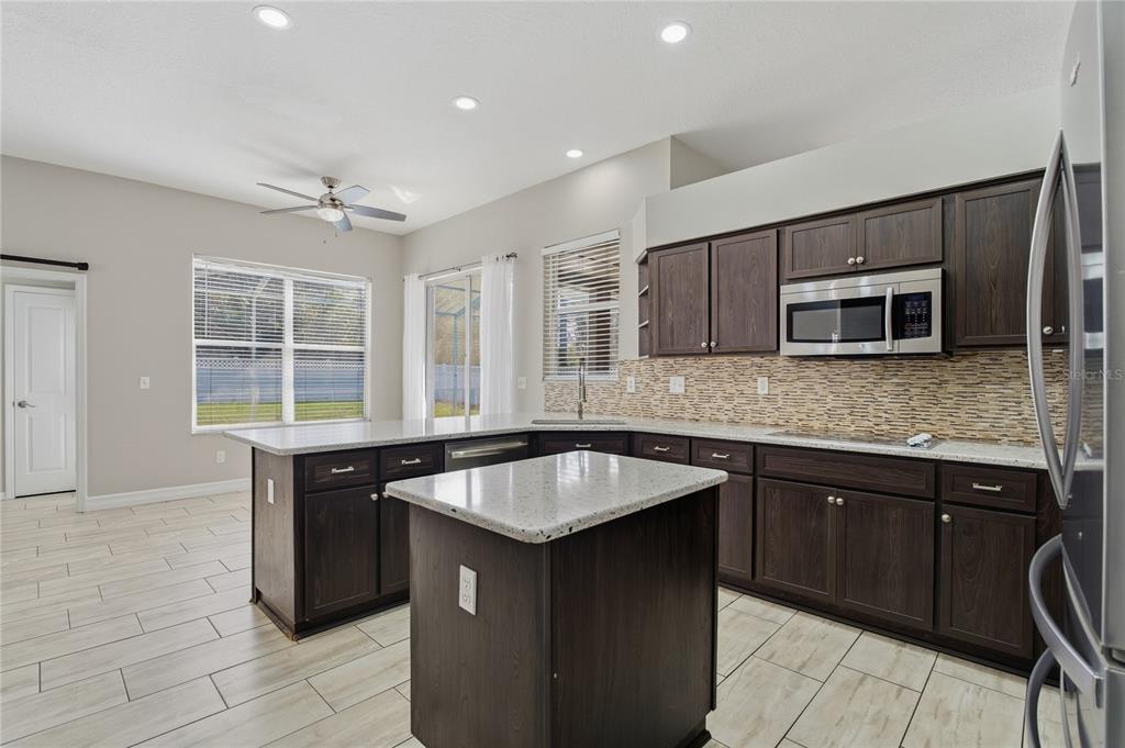 17431 Isbell Lane Odessa, FL 33556 - Photo 8 of 47 a kitchen with granite countertop sink island and windows