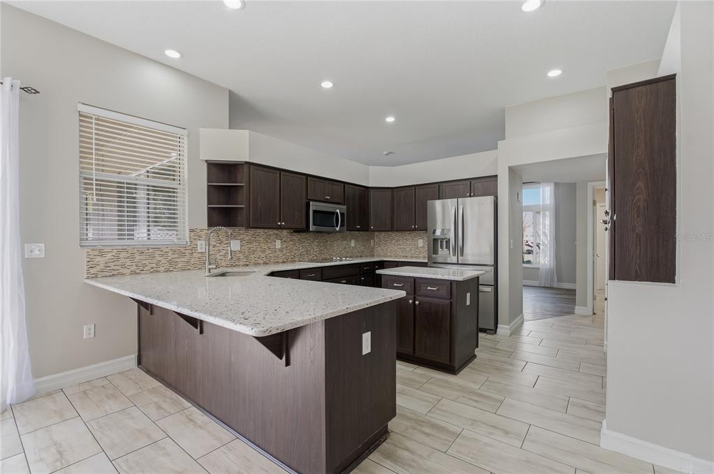 17431 Isbell Lane Odessa, FL 33556 - Photo 9 of 47 a kitchen with stainless steel appliances granite countertop a sink stove and refrigerator