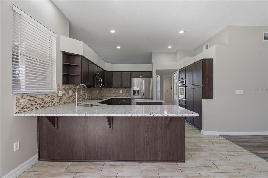 17431 Isbell Lane Odessa, FL 33556 - Photo 10 of 47 a large kitchen with stainless steel appliances granite countertop a sink a oven and a granite counter tops