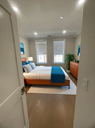 a bedroom with a bed and wooden floor