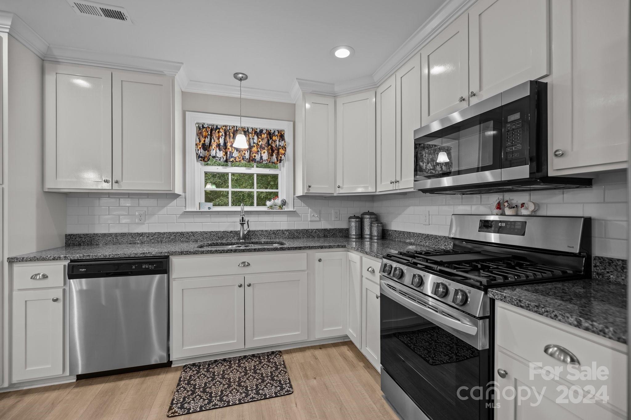 378 Boyd Faile Road Heath Springs, SC 29058 - Photo 4 of 28 a kitchen with granite countertop a stove a sink and a microwave