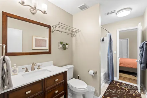 a bathroom with a sink a toilet a shower and a mirror