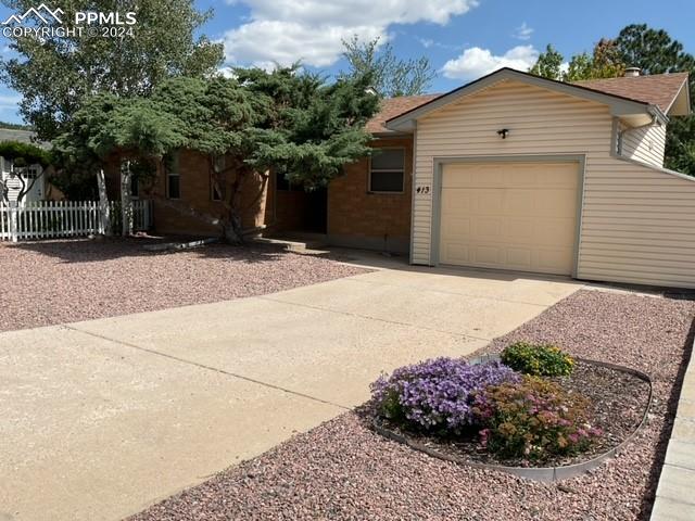 413 Chelton Road Colorado Springs, CO 80910 - Photo 3 of 27 a front view of a house with a yard and a garage