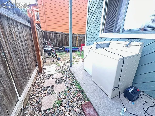 a view of a backyard with a wooden fence and a couch
