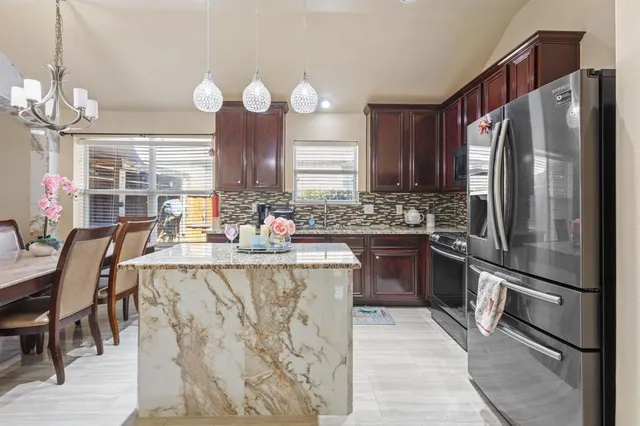 a kitchen with stainless steel appliances granite countertop a sink refrigerator and cabinets