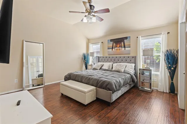 a spacious bedroom with a bed and wooden floor