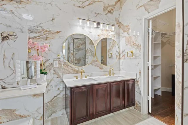 a bathroom with a double vanity sink mirror and shower